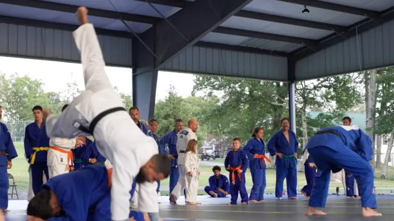 A judoka mid-throw under the pavilion at International Judo Camp
